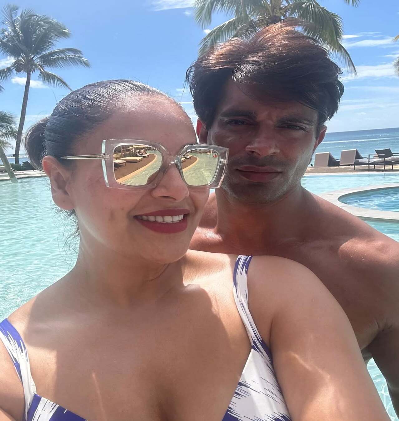 Another pic from another beachside vacation. Bipasha is wearing her signature rectangular golden shades and a swimsuit. Karan, too appears ready for a swim in the pristine blue waters behind them